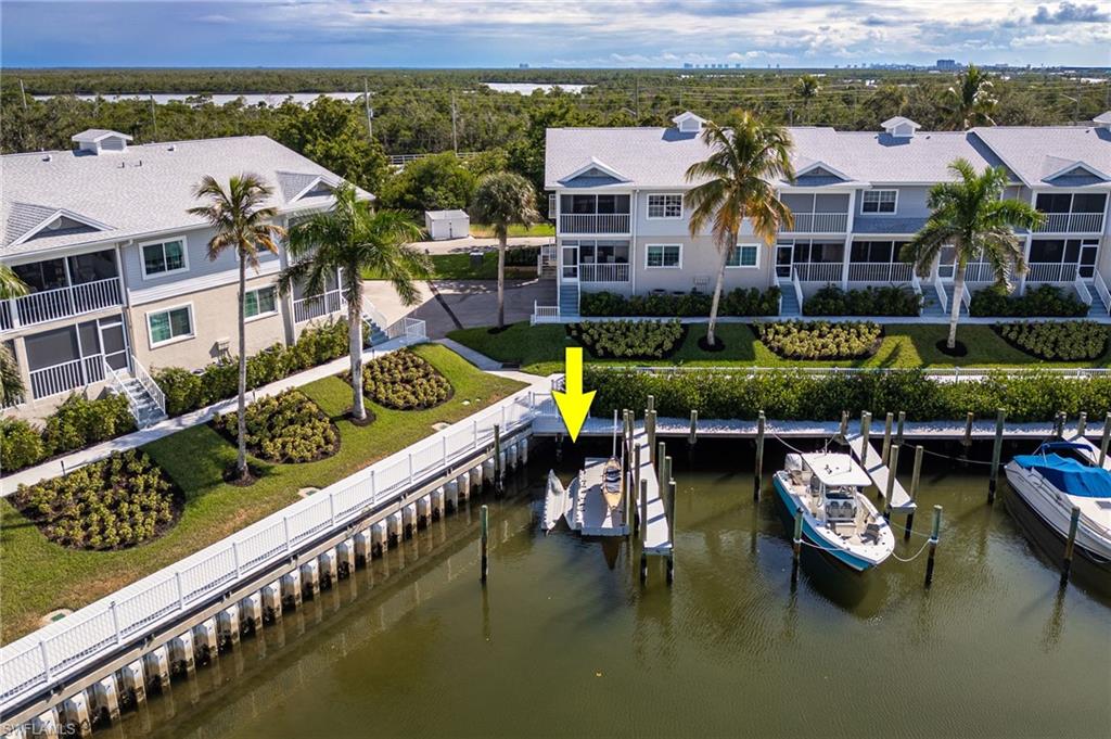 Dock area with a water view, boat lift, and a sunroom