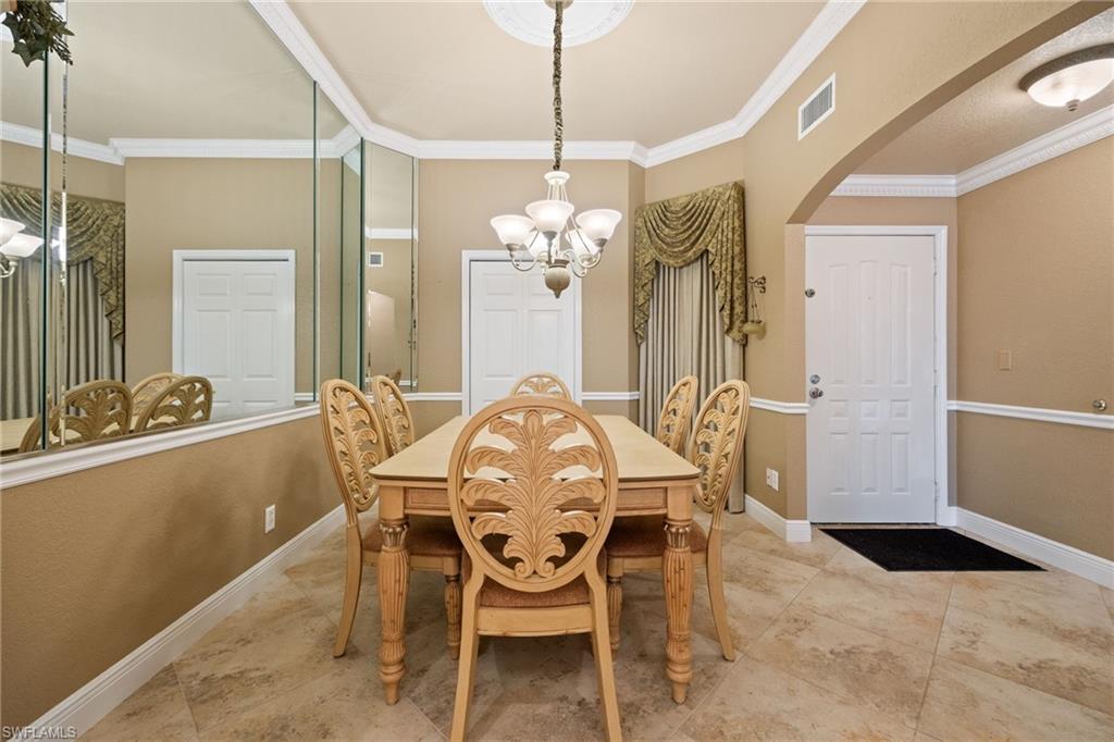 Dining space featuring a chandelier, ornamental molding, and arched walkways