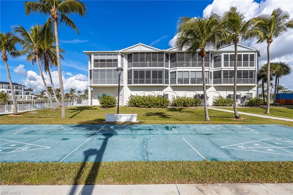 View of community with shuffleboard and a lawn