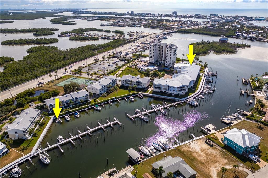 Drone / aerial view of numerous boat docks and a nearby body of water