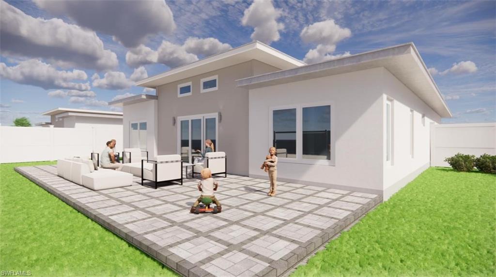 Rear view of house with a patio area, stucco siding, and a fenced backyard