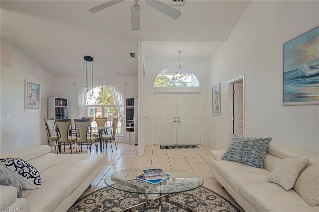 Living room with light tile patterned floors and high vaulted ceiling