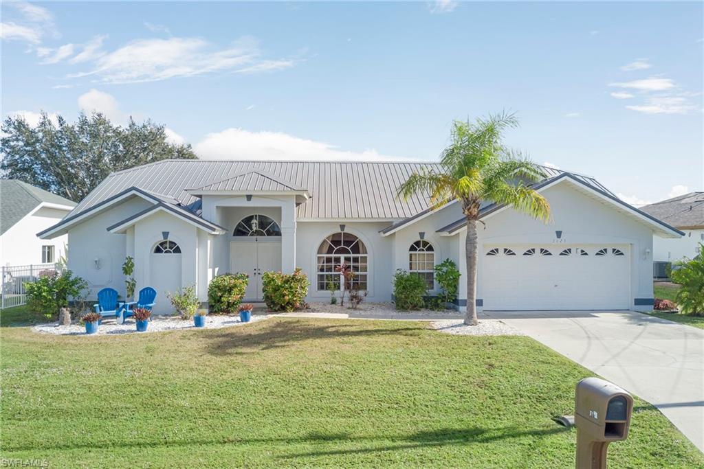 Ranch-style home featuring stucco siding, concrete driveway, a front yard, and an attached garage