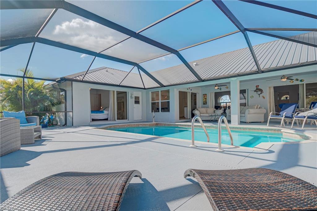 Swimming pool with an outdoor living space, a patio, a sunroom, and glass enclosure