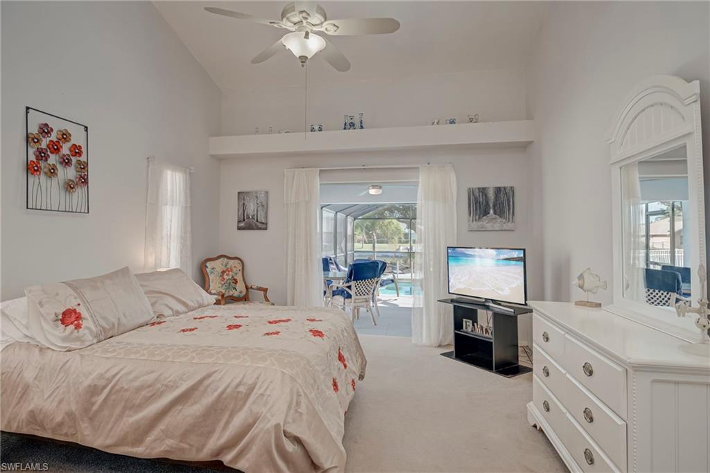 Bedroom with access to outside, light carpet, a ceiling fan, and vaulted ceiling
