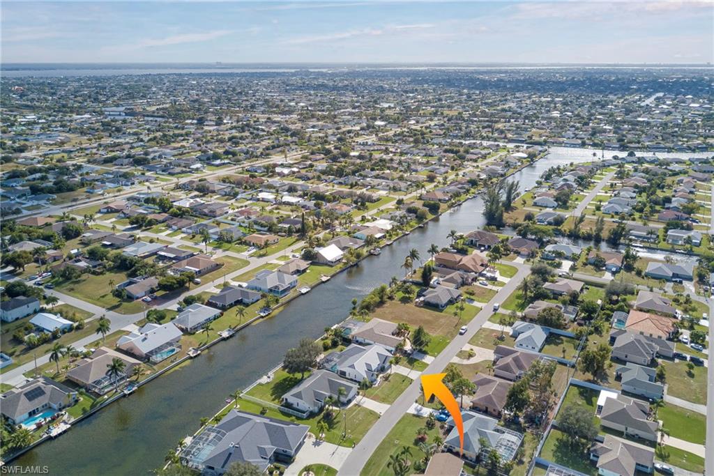 Aerial view of property and surrounding area featuring nearby suburban area