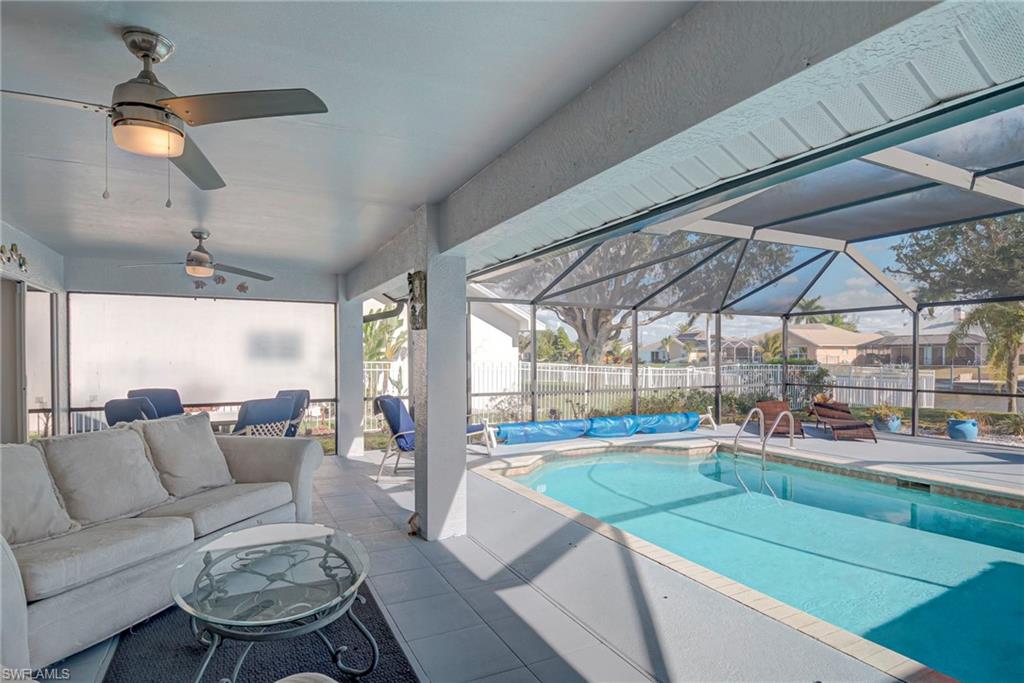 View of swimming pool featuring a patio area, a fenced backyard, a lanai, a sunroom, and an outdoor living space