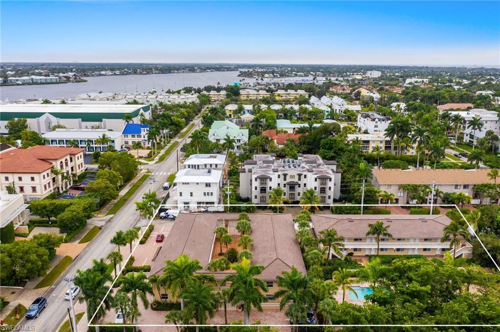 Aerial view of property and surrounding area with a nearby body of water and property parcel outlined