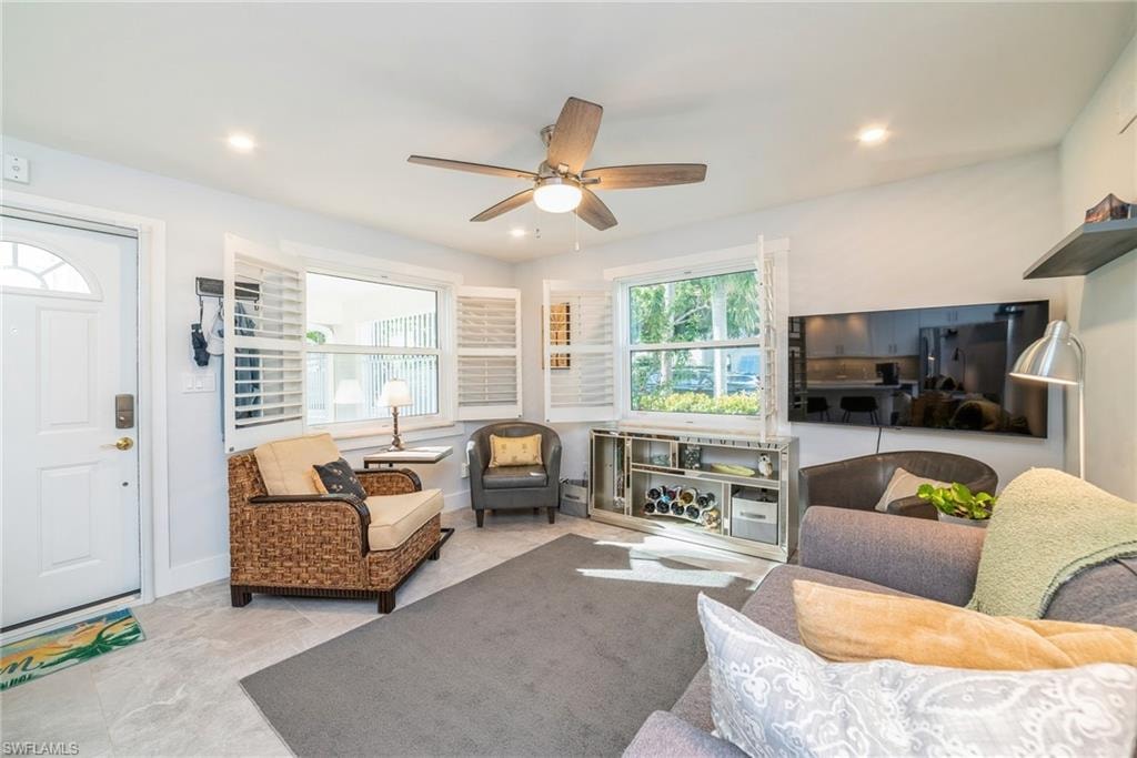 Living area featuring a ceiling fan and baseboards