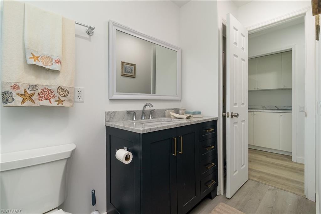 Bathroom featuring vanity, light wood finished floors, and a walk in closet