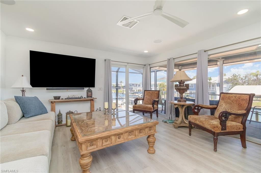 Living area featuring light wood-style floors, ceiling fan, and recessed lighting