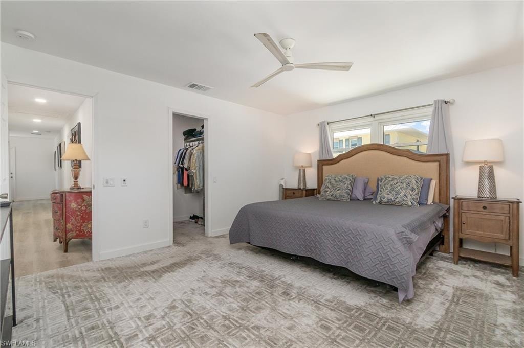 Bedroom featuring a spacious closet and a ceiling fan