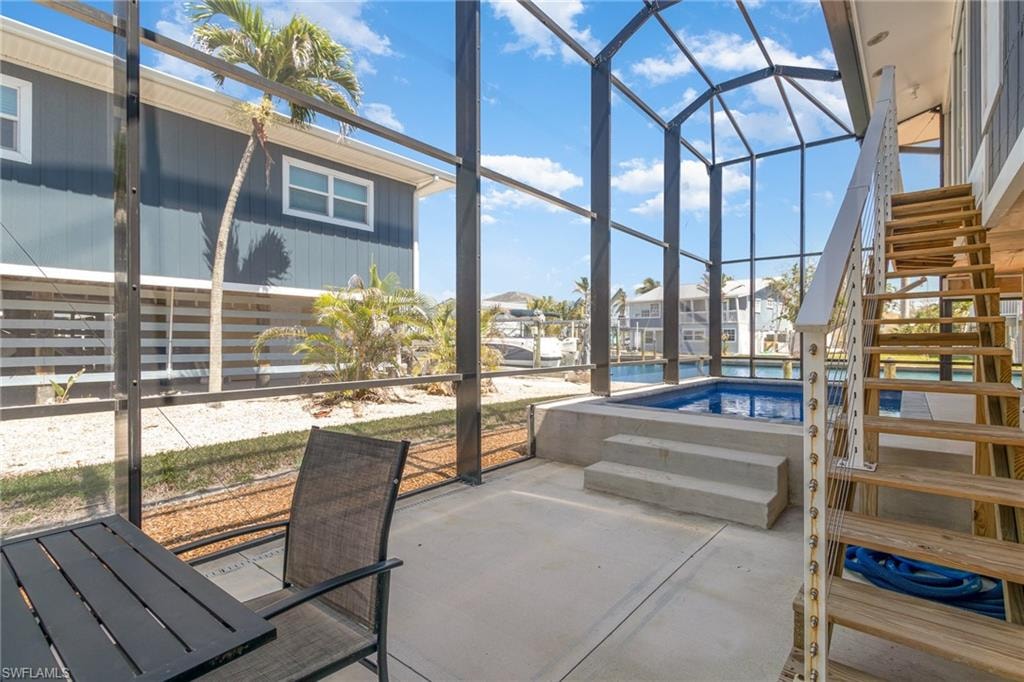 View of patio / terrace with a sunroom, a lanai, an outdoor pool, and stairway