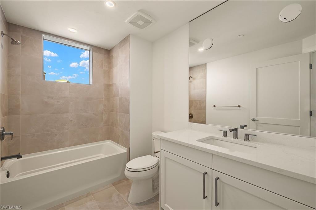 Bathroom 3 featuring vanity, bathing tub / shower combination, light tile patterned floors, and recessed lighting
