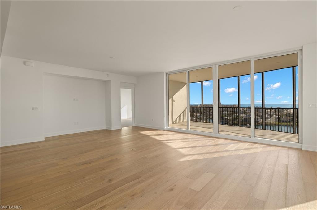 floor to ceiling windows all around and light wood finished floors
