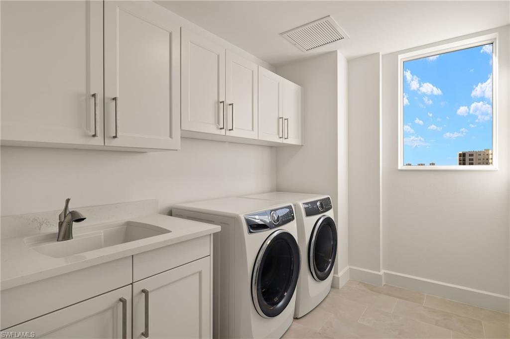 Lots of cabinets space in the laundry room with full size washer and clothes dryer