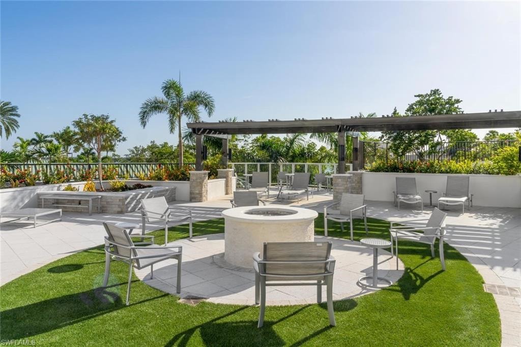 Scenic patio with fire pit surrounded by lush greenery.