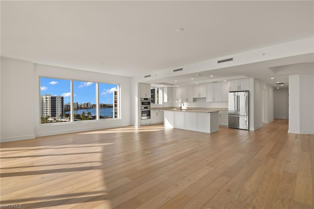 Large great room with lots of natural lighting coming through the sliding glass doors and floor to ceiling windows