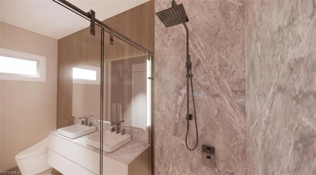 Bathroom with a marble finish shower and double vanity