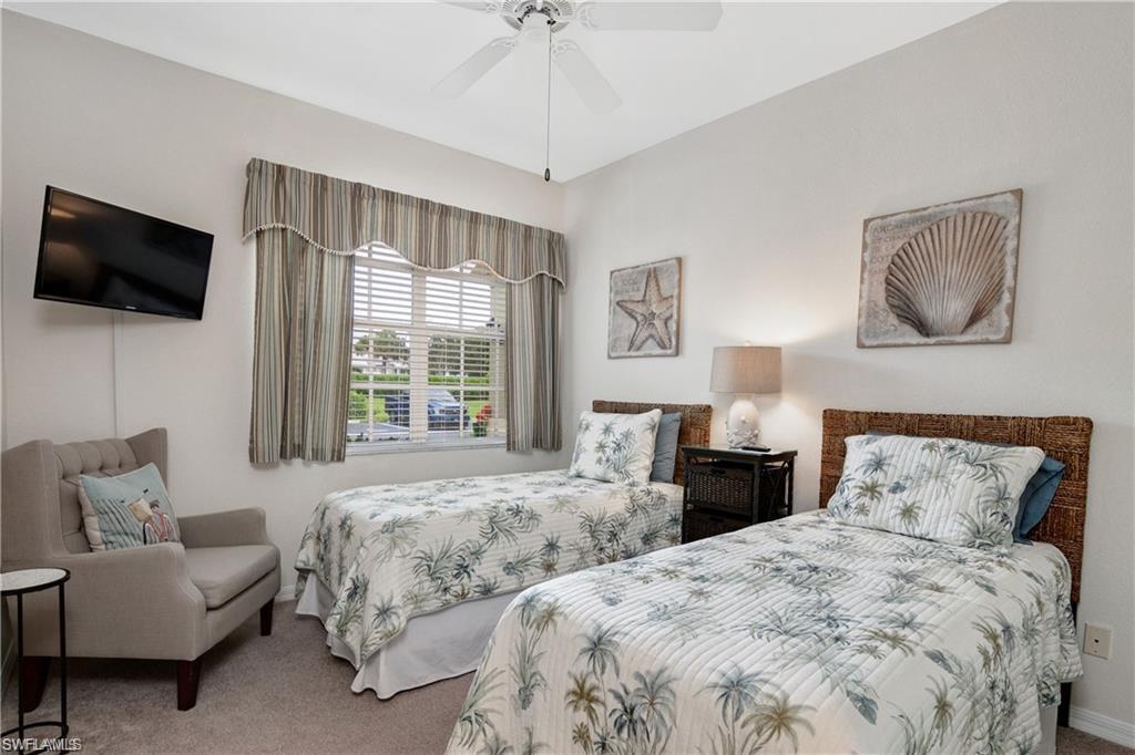 Carpeted bedroom with a ceiling fan