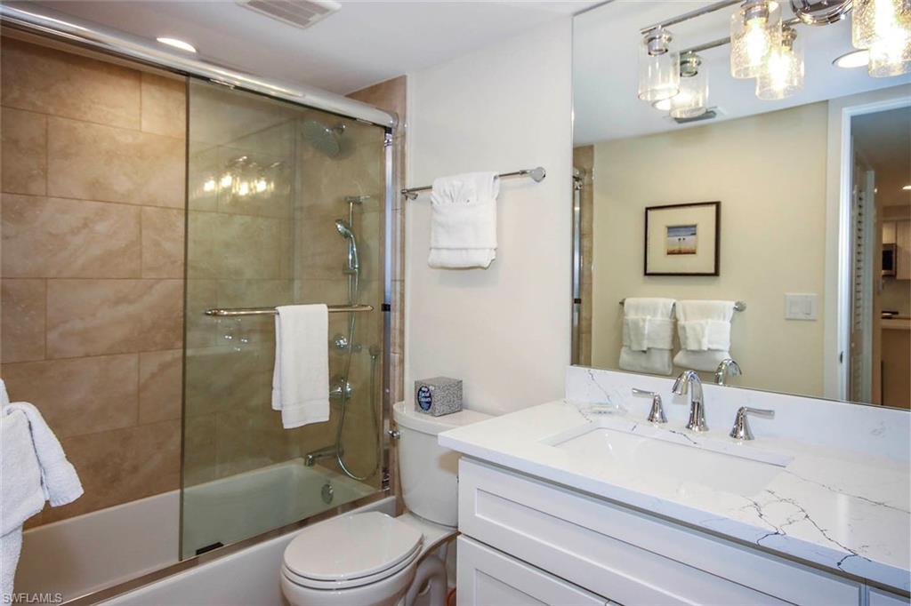 Full bathroom with vanity and bath / shower combo with glass door