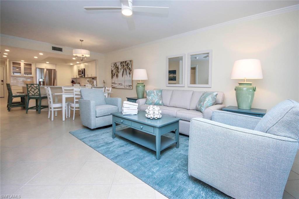 Living area featuring crown molding, light tile patterned flooring, and a ceiling fan