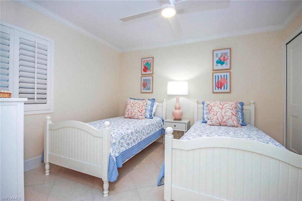 Bedroom featuring ornamental molding, tile patterned floors, and ceiling fan