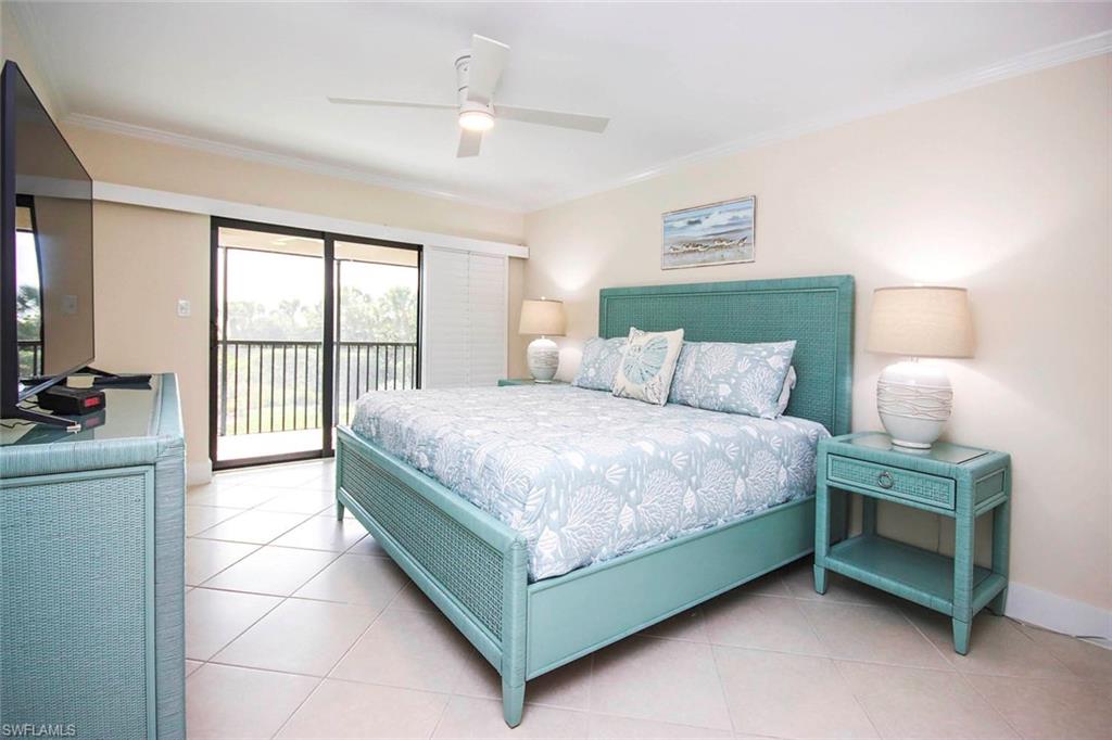 Bedroom with access to outside, light tile patterned floors, ornamental molding, and ceiling fan