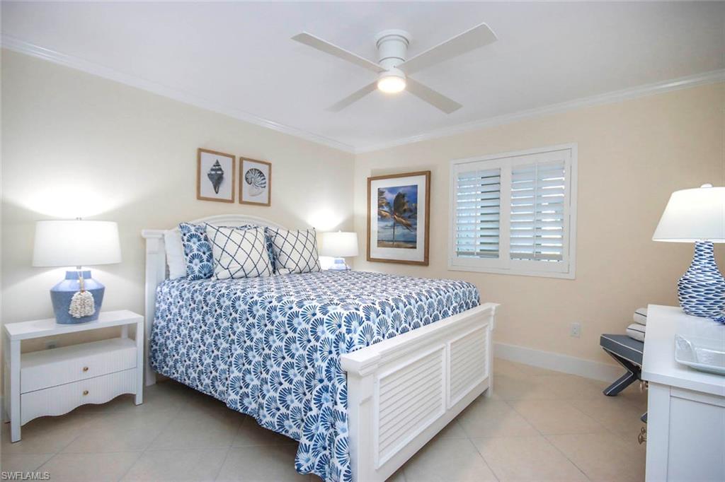 Bedroom with crown molding, ceiling fan, and light tile patterned flooring