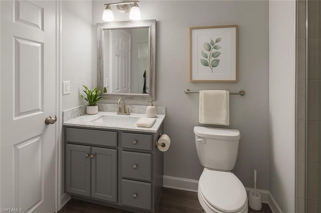 Virtually staged full bathroom featuring vanity, dark wood-style flooring, and a shower