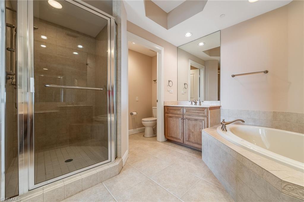 Bathroom featuring vanity, a stall shower, light tile patterned floors, recessed lighting, and a bath
