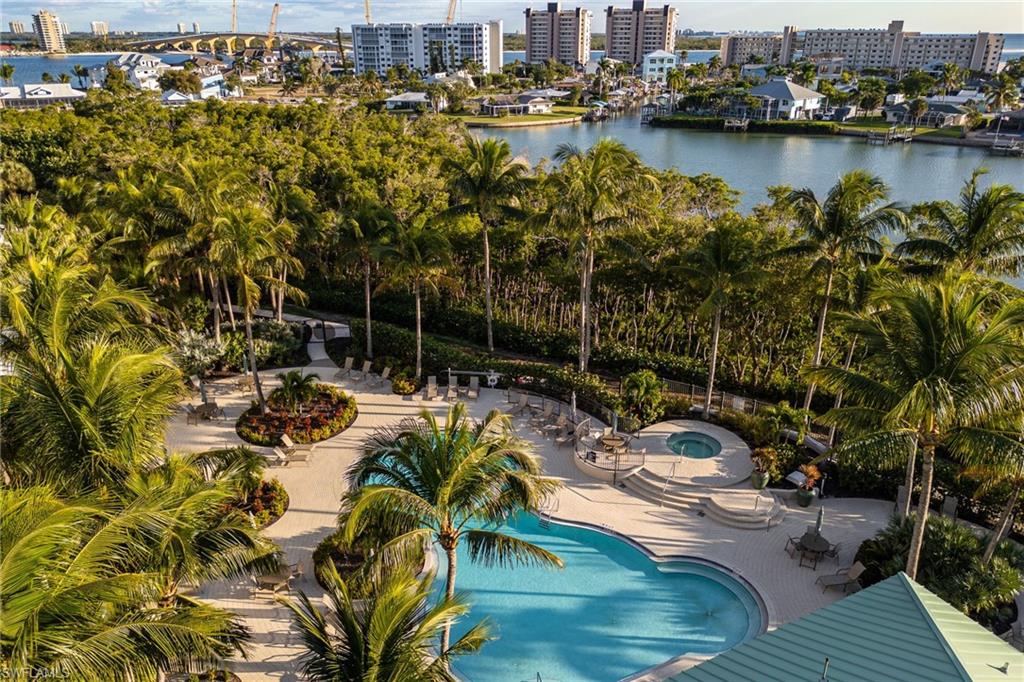 Community pool featuring a city view, a patio, a hot tub, and a water view