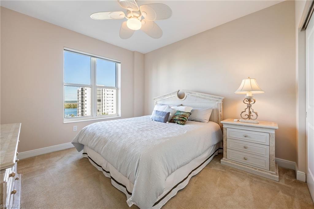 Bedroom with ceiling fan and light carpet