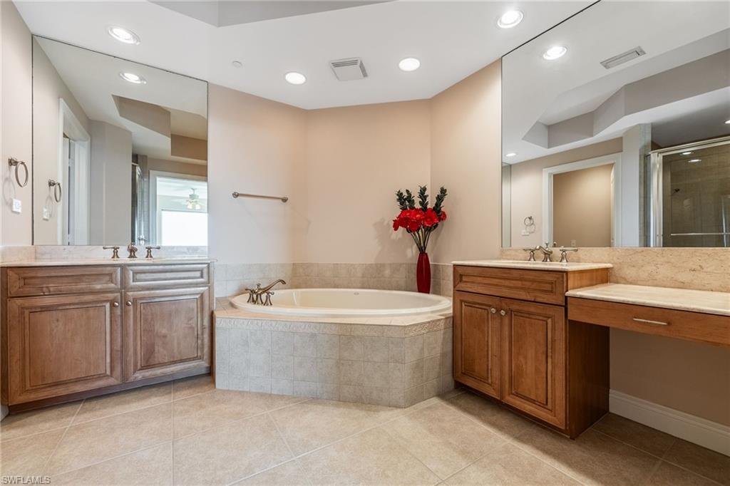Full bath with two vanities, recessed lighting, a bath, a stall shower, and light tile patterned floors