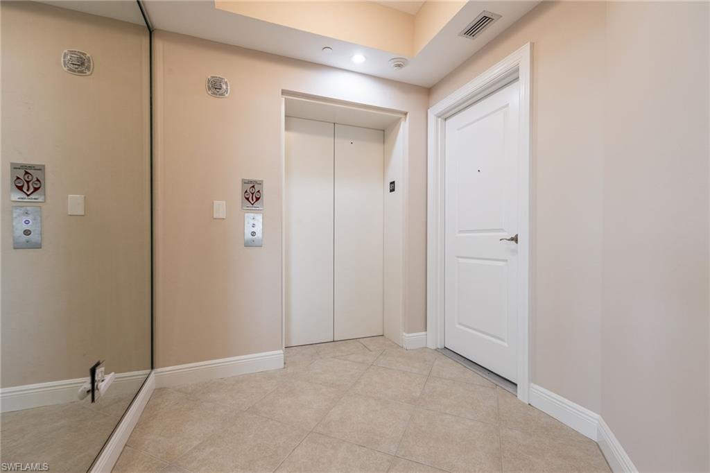 Hall with light tile patterned flooring and elevator
