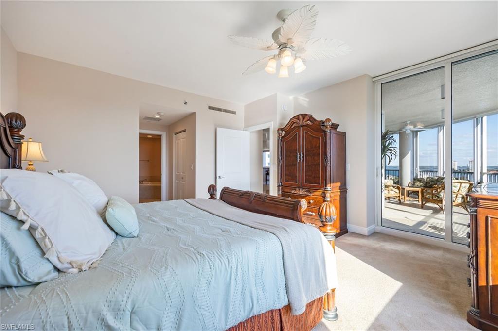 Carpeted bedroom with access to exterior, a ceiling fan, and connected bathroom