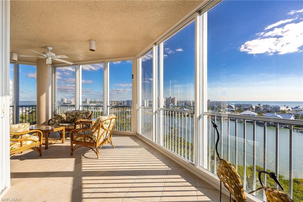 Sunroom featuring tile patterned floors, floor to ceiling windows, a water view, and a textured ceiling