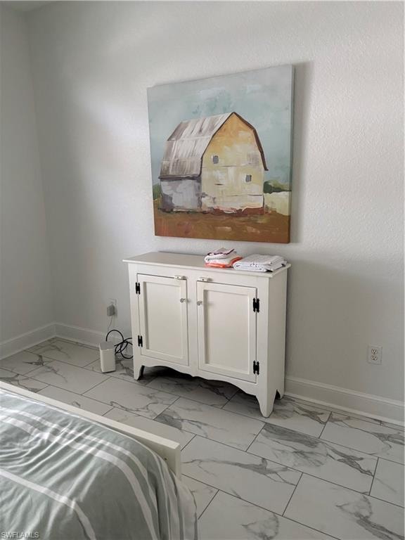Bedroom with light marble finish floors and baseboards