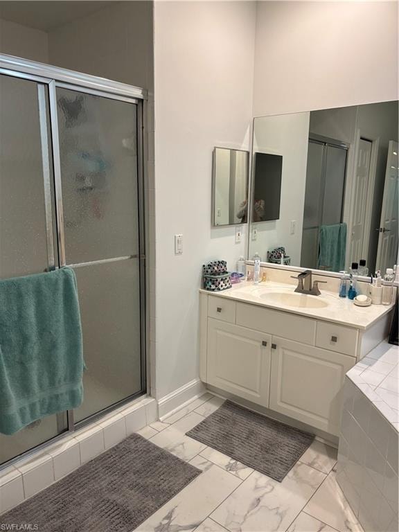 Bathroom featuring vanity, a stall shower, and light marble finish flooring
