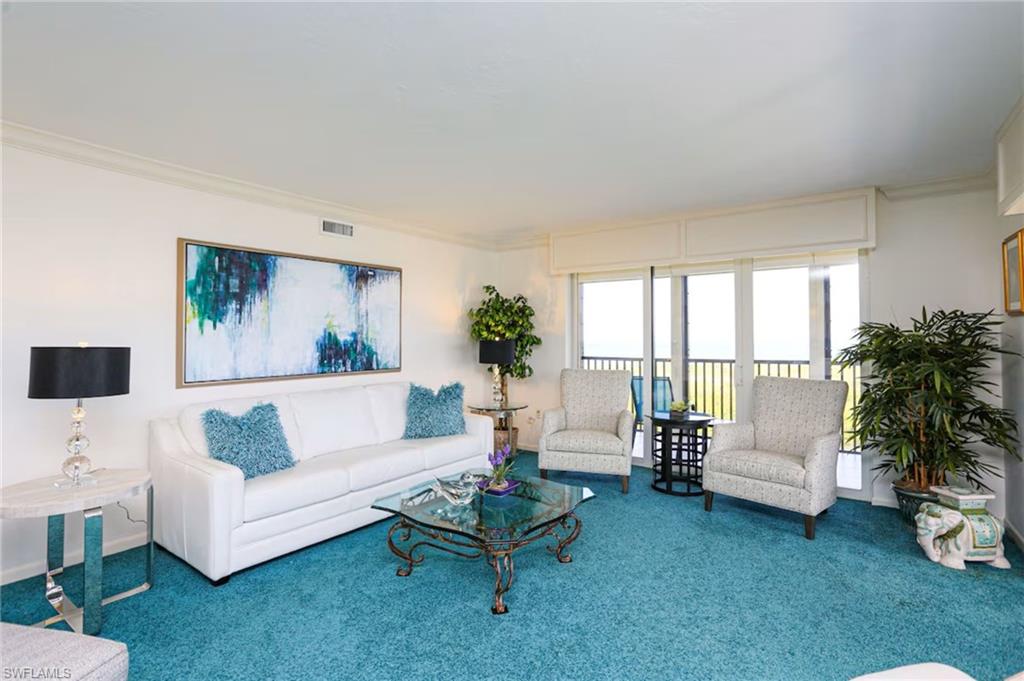 Living area featuring crown molding and carpet flooring