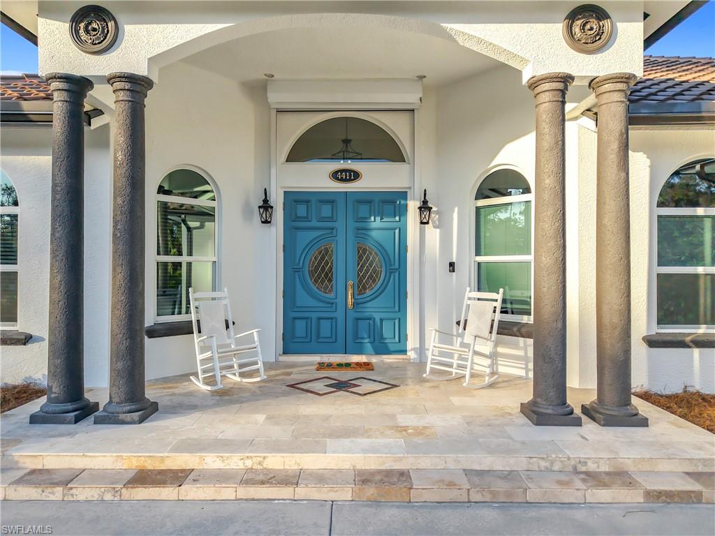 Entrance to property featuring covered porch, stucco siding, and a tile roof