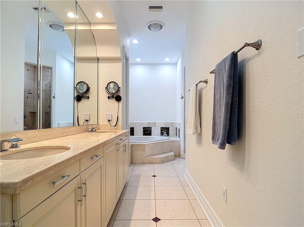 Full bath with recessed lighting, double vanity, a garden tub, and light tile patterned floors