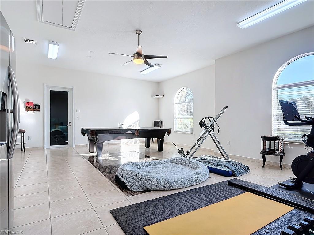 Workout room featuring light tile patterned flooring and a ceiling fan