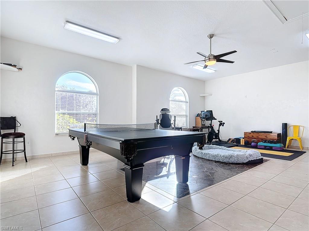 Playroom with attic access, tile patterned flooring, plenty of natural light, and ceiling fan