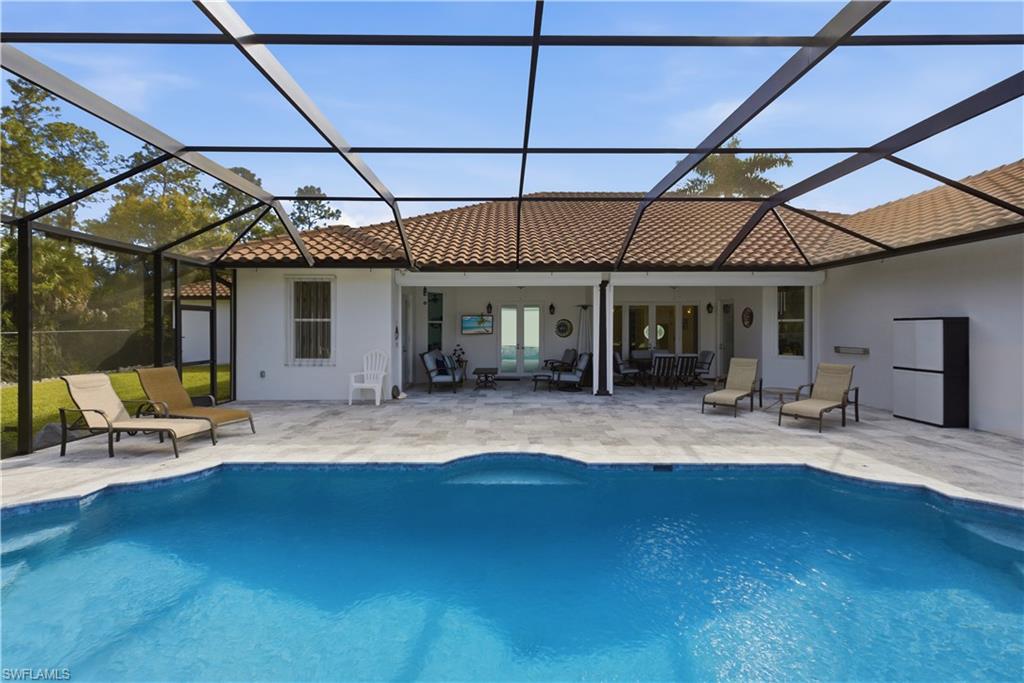 Rear view of house featuring a sunroom, a patio area, and stucco siding