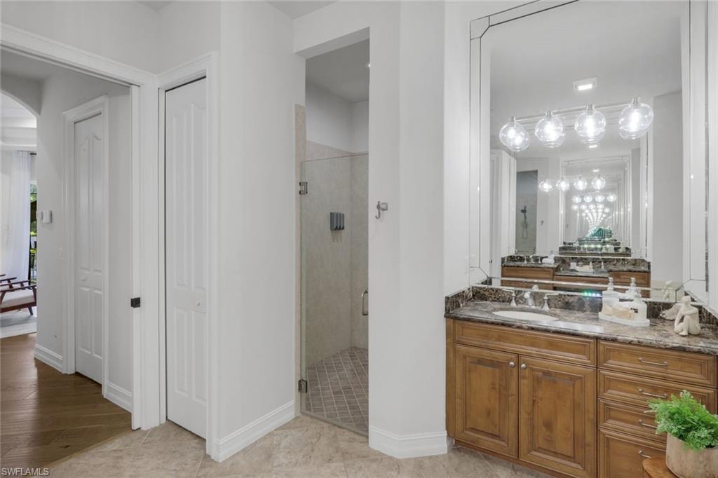 Bathroom with vanity, a stall shower, and a closet