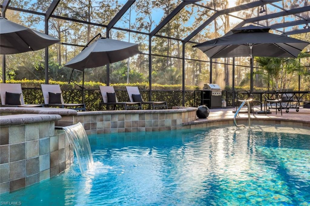 Swimming pool with glass enclosure, grilling area, a sunroom, and a patio