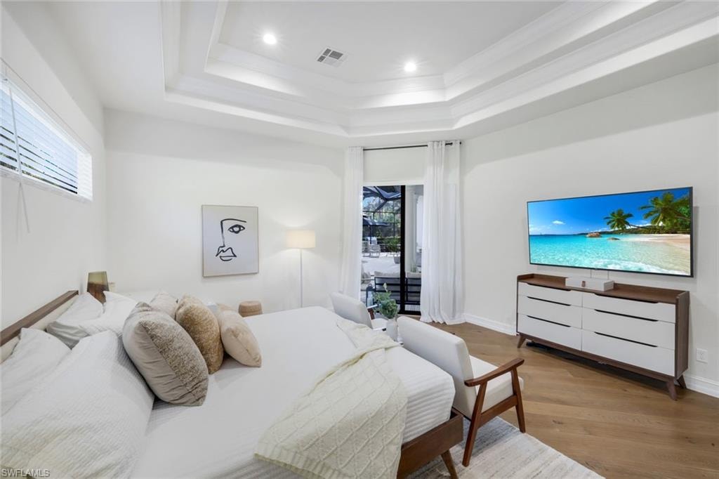 Bedroom with wood finished floors, access to exterior, recessed lighting, and ornamental molding