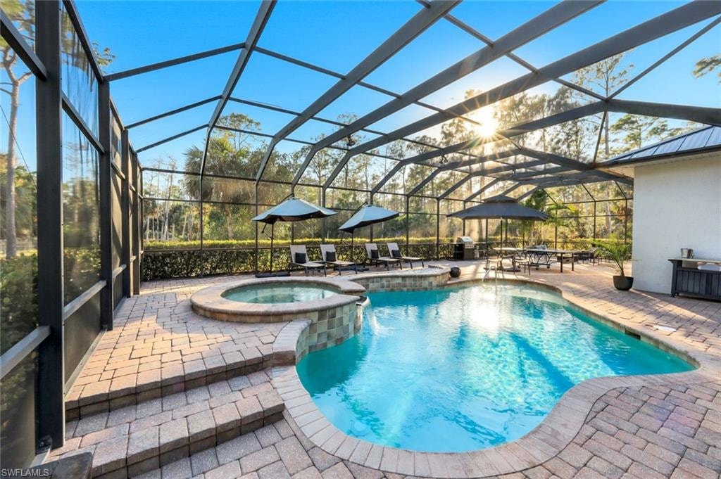 Integrated pool / spa featuring glass enclosure, a patio, and a sunroom