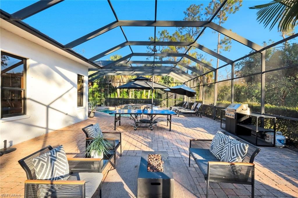 View of patio / terrace featuring a lanai, outdoor lounge area, a sunroom, and grilling area